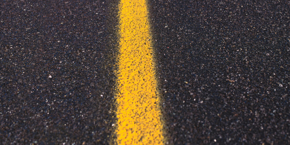 Asphalt road texture with yellow stripe