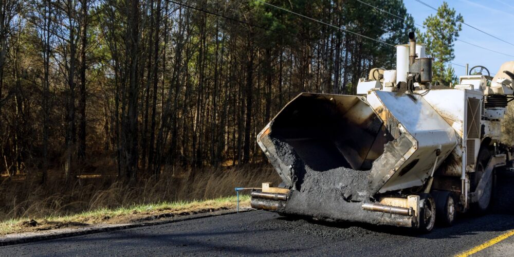 Industrial machinery working with asphal industrial laying fresh asphalt on construction site