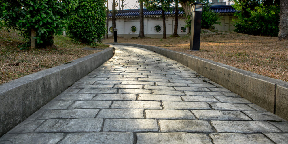 Paving stone road. Old pavement of square cobblestone sidewalk in Taipei. Garden patio in backyard stone brick pavers in Taiwan. Concrete paver block floor for background.
