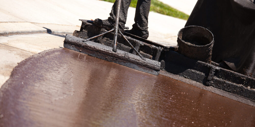 Road Worker Resurfacing Street with Hot Tar.
