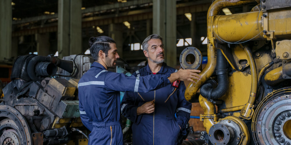 Technicians work at train engine repair shop. Machinery and engineering.